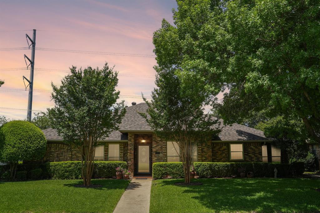 12929 Jasoncrest Trail Dallas, TX 75243 - Photo 36 of 38 Brick exterior with a gabled roof and lush front yard landscaping