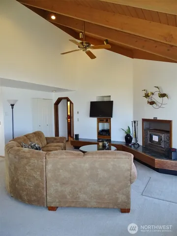 a living room with furniture a ceiling fan and a window