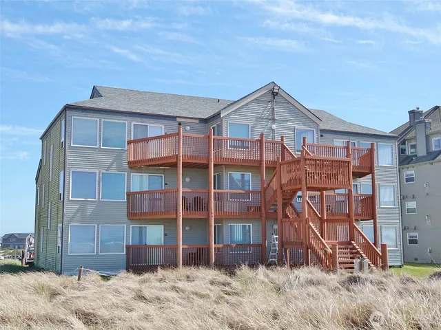 a view of a house with a backyard and wooden fence