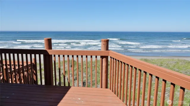 a view of wooden balcony with ocean