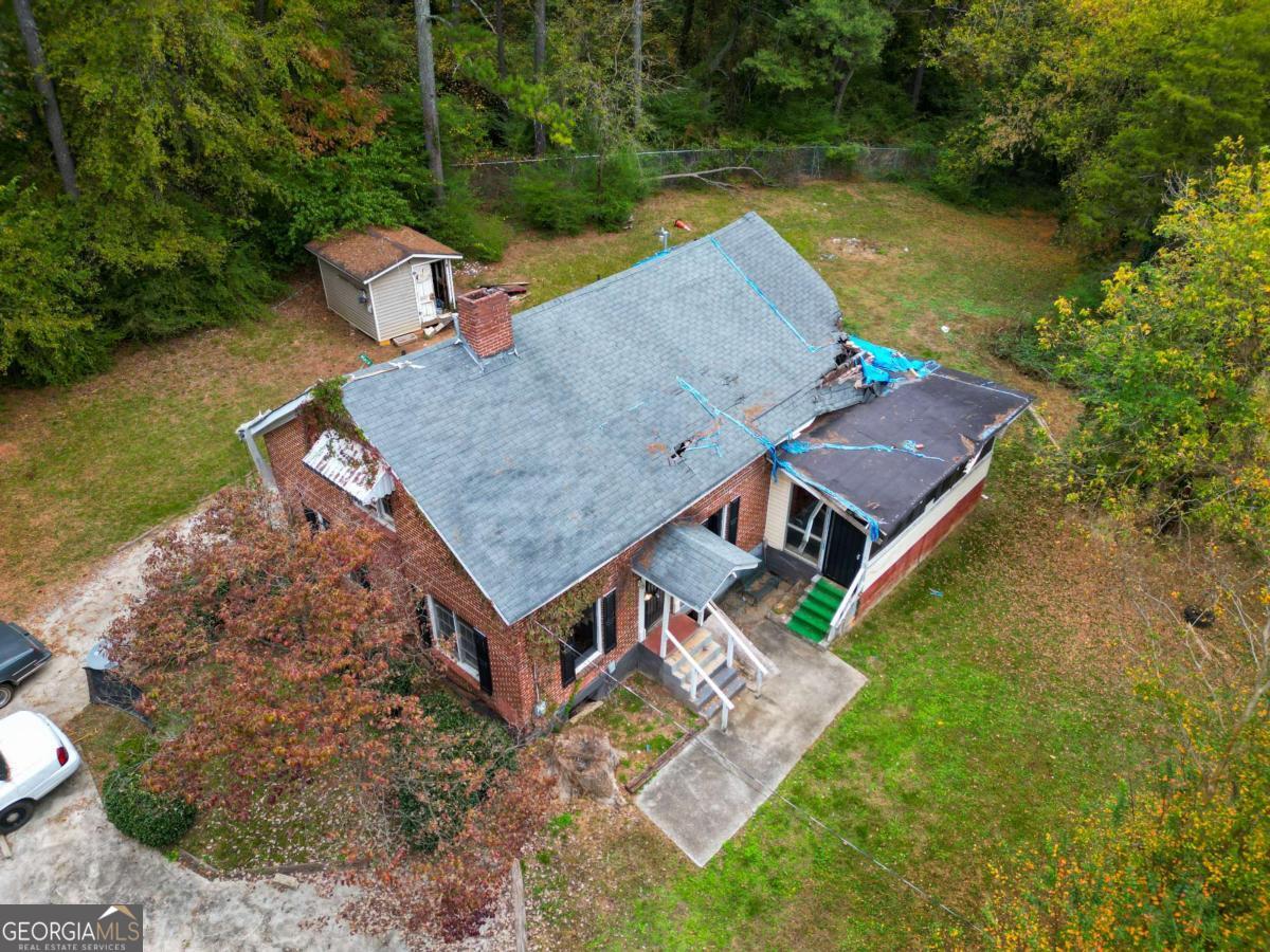 an aerial view of a house with swimming pool and a yard
