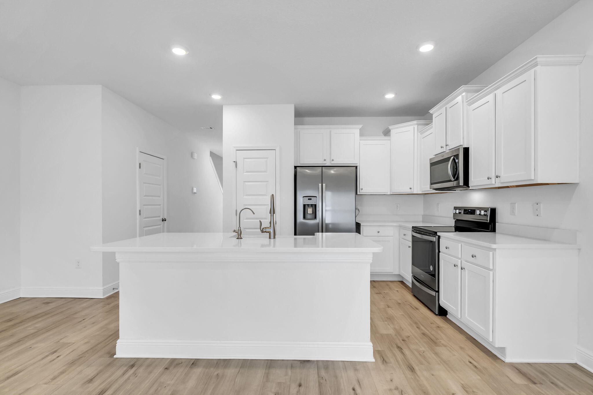 22 Redbird Loop Destin, FL 32541 - Photo 14 of 40 a large kitchen with stainless steel appliances a refrigerator a stove top oven a sink dishwasher and white cabinets with wooden floor