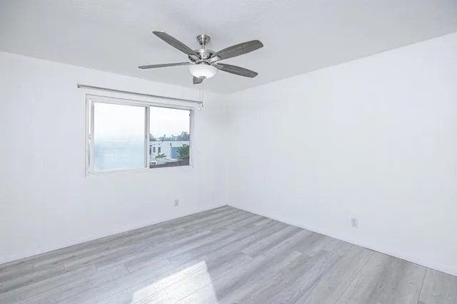a view of a big room with wooden floor closet and windows