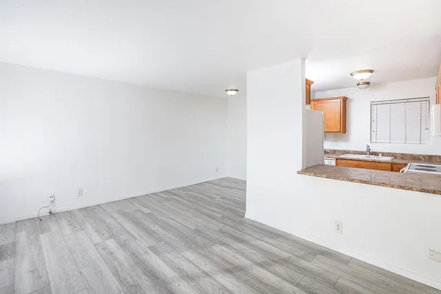 a view of a kitchen with wooden floor and a sink