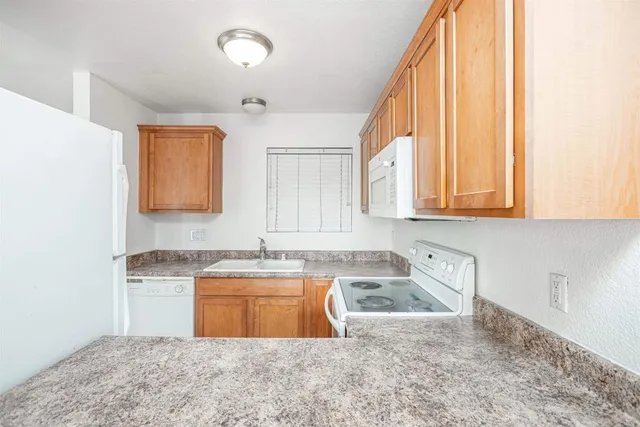 a kitchen with stainless steel appliances granite countertop a sink a stove a cabinets and a window