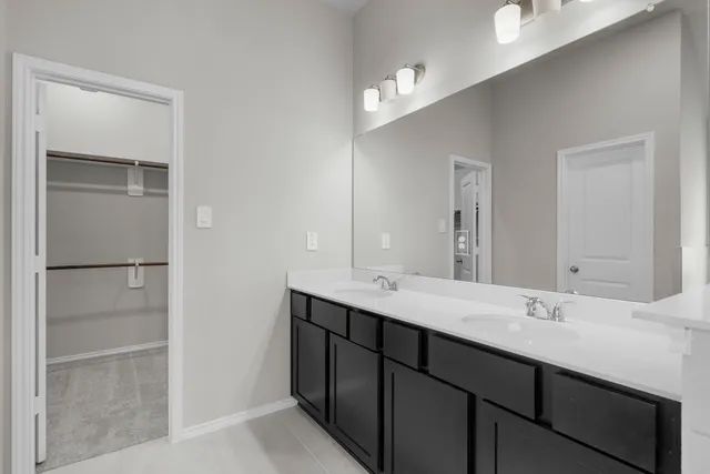 a bathroom with a double vanity sink and a mirror