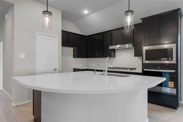 a kitchen with stainless steel appliances a refrigerator and a microwave