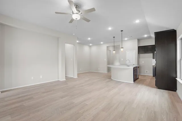 a view of a kitchen with a refrigerator and a stove top oven