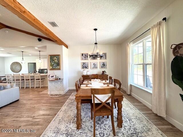 34424 Mitigation Trail Callahan, FL 32011 - Photo 10 of 44 a dining room with wooden floor a chandelier a wooden table and chairs