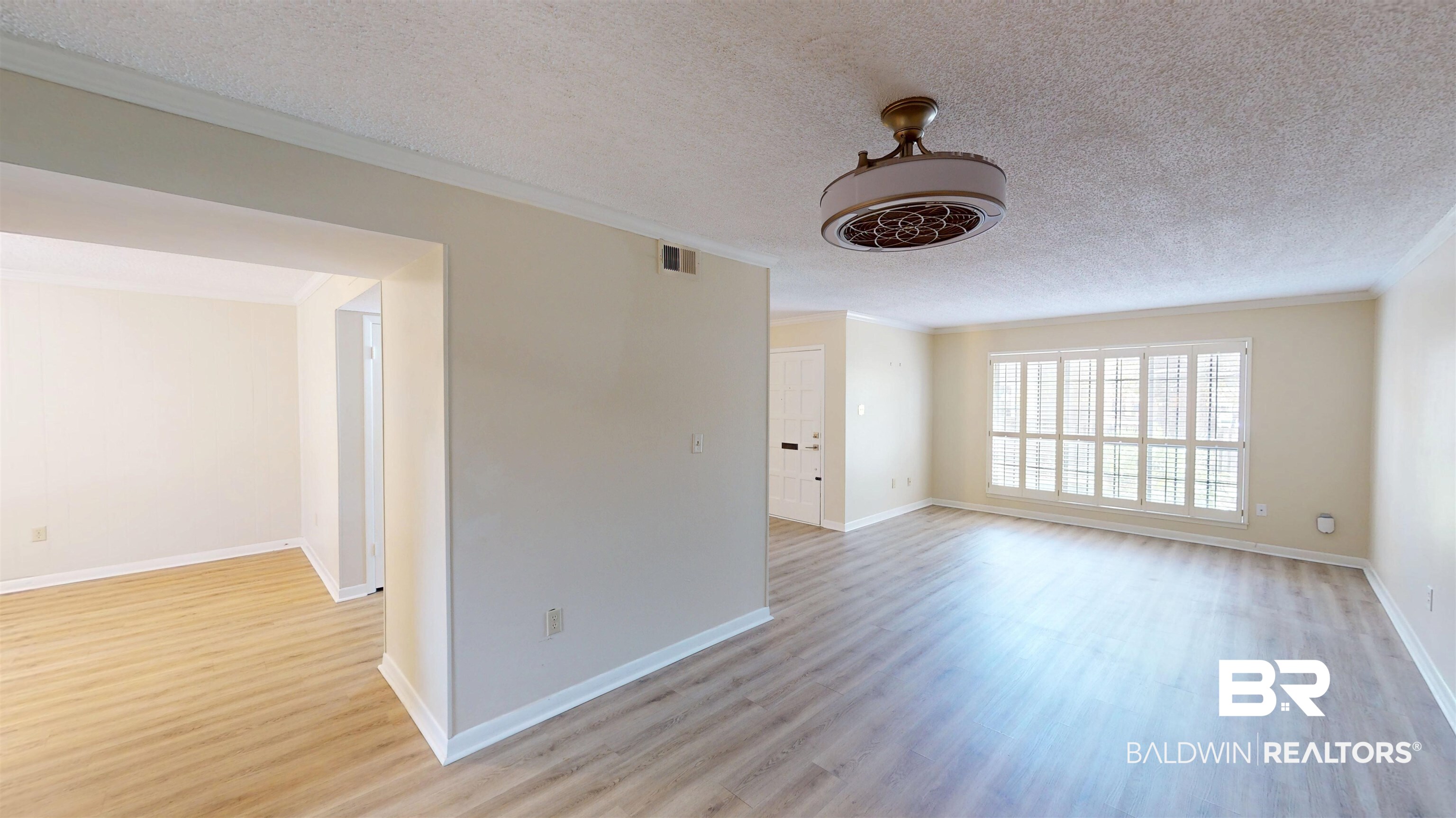 2901 Grant Street, Unit 902 Mobile, AL 36606 - Photo 4 of 35 Empty room featuring crown molding, a textured ceiling, and light wood-type flooring