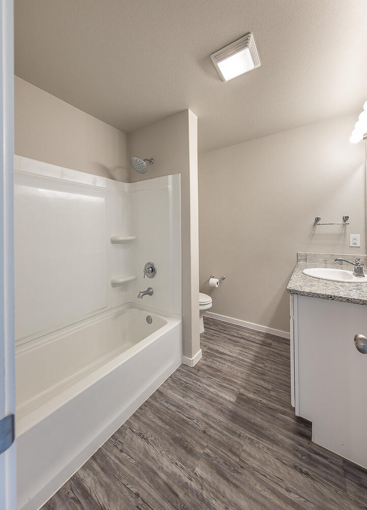 7526 31st Place Lubbock, TX 79407 - Photo 11 of 22 a bathroom with a bathtub a toilet a sink and a shower