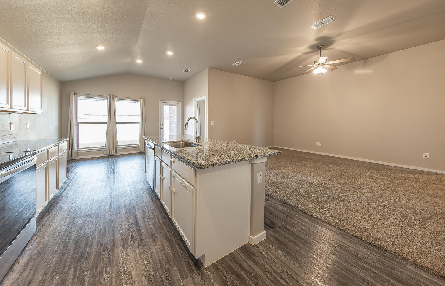 7526 31st Place Lubbock, TX 79407 - Photo 3 of 22 a kitchen with granite countertop a stove and wooden floor
