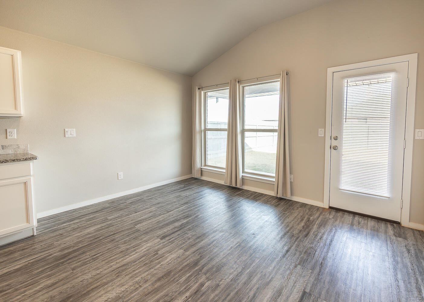 7526 31st Place Lubbock, TX 79407 - Photo 7 of 22 an empty room with wooden floor and windows
