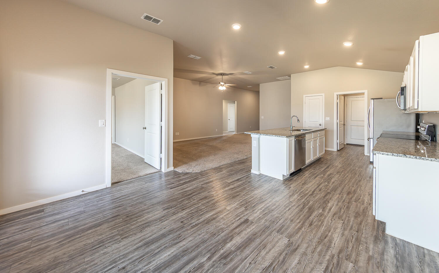 7526 31st Place Lubbock, TX 79407 - Photo 8 of 22 a open kitchen with stainless steel appliances a large counter top a sink and a refrigerator