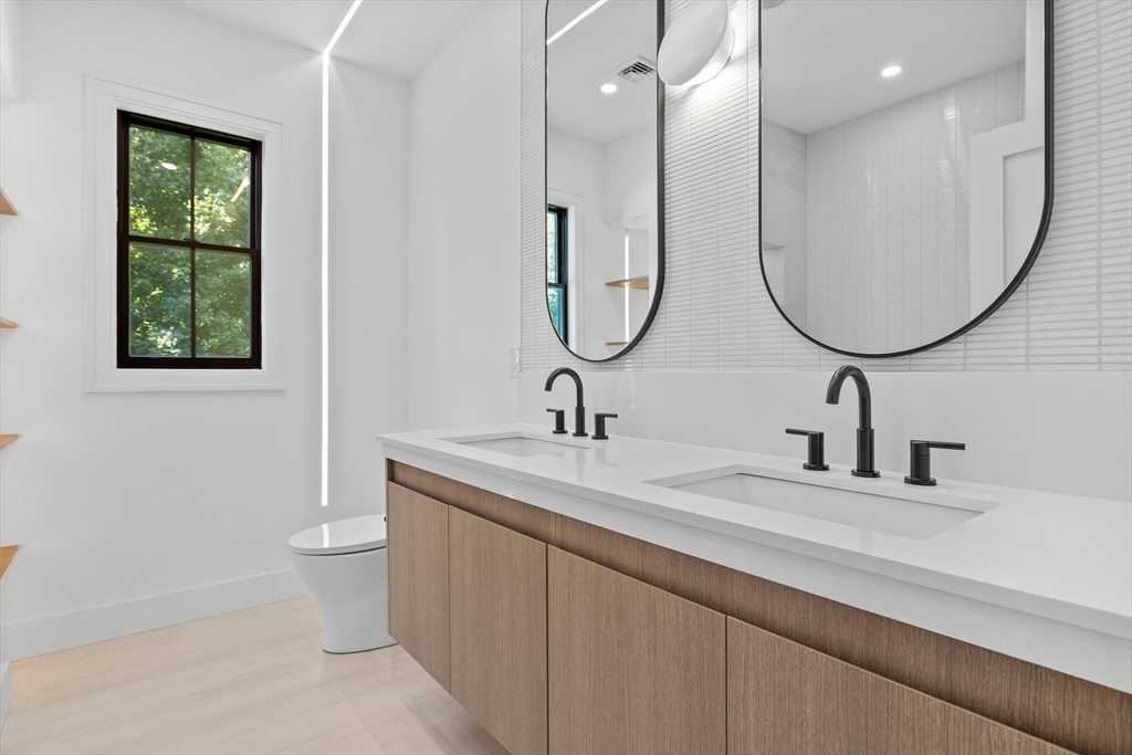 34 Garrison Road Wellesley, MA 02482 - Photo 16 of 28 a bathroom with a double vanity sink and a mirror