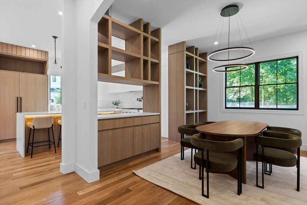 34 Garrison Road Wellesley, MA 02482 - Photo 4 of 28 a kitchen with a dining table chairs appliances and cabinets