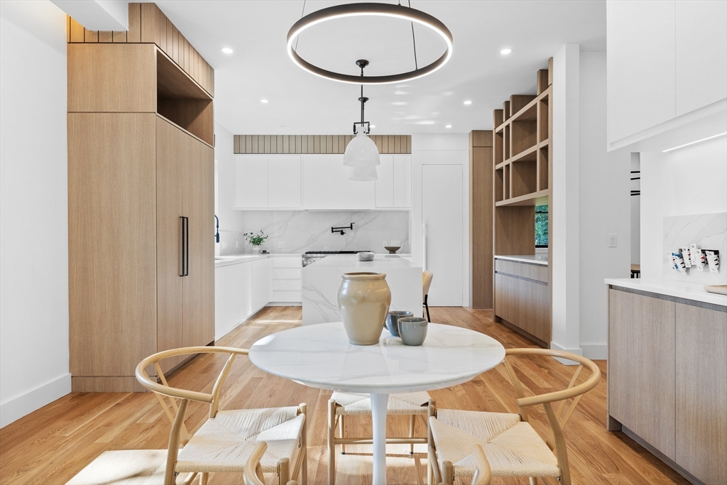 34 Garrison Road Wellesley, MA 02482 - Photo 7 of 28 a kitchen with stainless steel appliances a dining table chairs and wooden floor