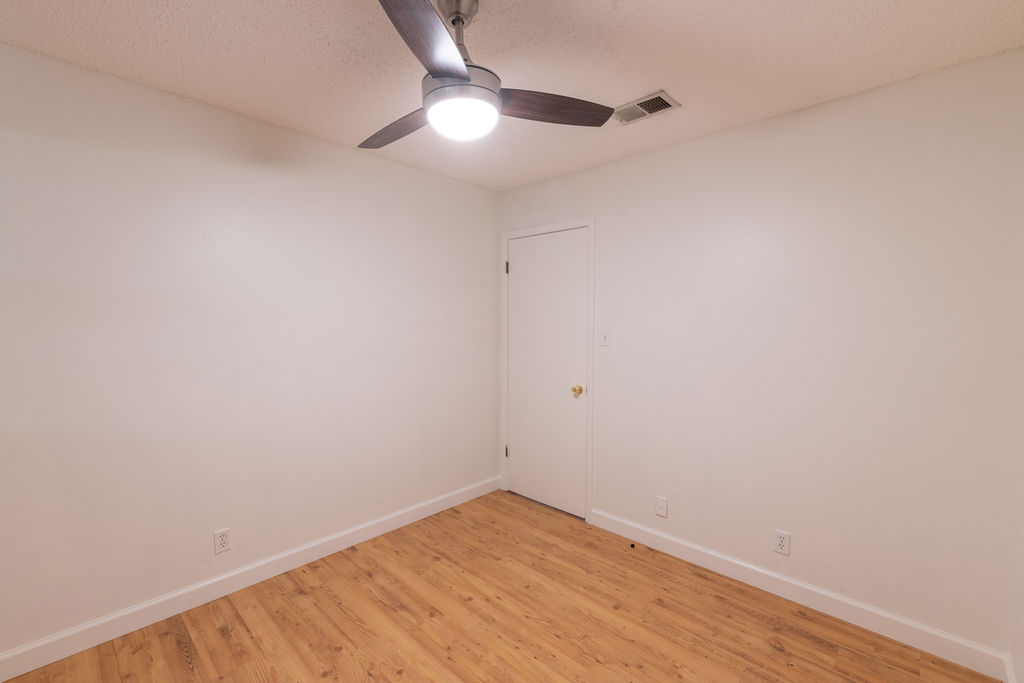 5310 Presidio Road Austin, TX 78745 - Photo 22 of 34 A well-lit bedroom features hardwood flooring and a stylish ceiling fan.