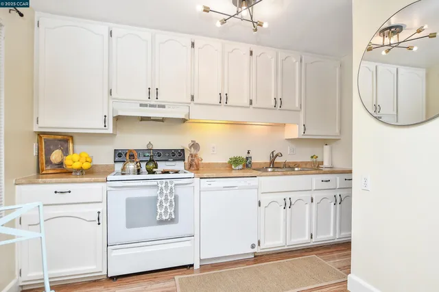 a kitchen with white cabinets and white appliances