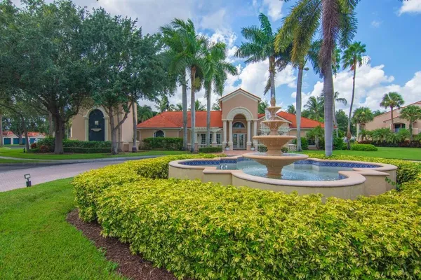 a front view of a house with swimming pool and green space
