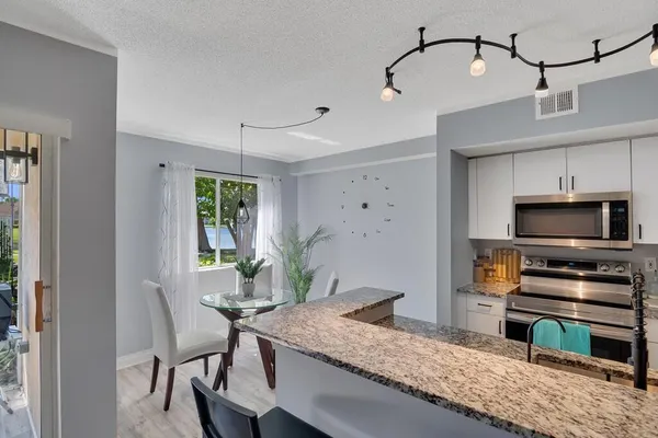 a kitchen with kitchen island a sink stove and microwave