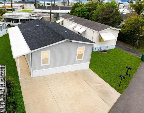 a view of a house with a yard and potted plants