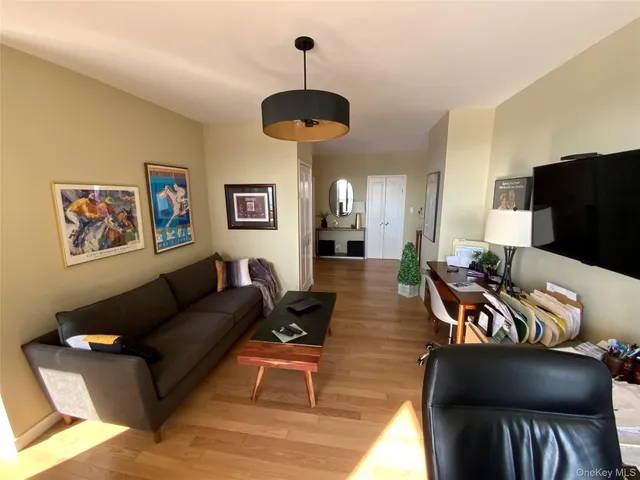 a living room with furniture a chandelier and a flat screen tv