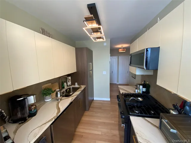 a kitchen with stainless steel appliances granite countertop a sink and a stove