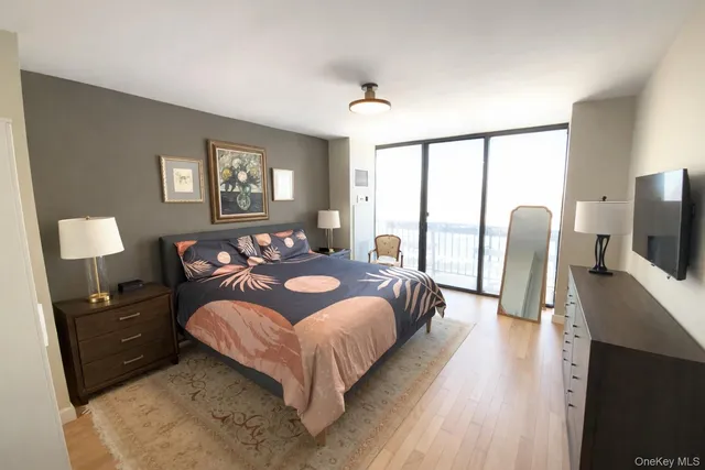 a spacious bedroom with a bed and wooden floor