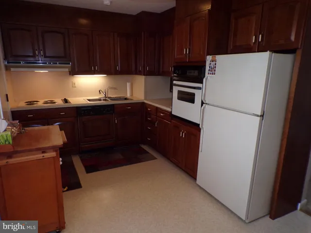a kitchen with a refrigerator and a stove top oven