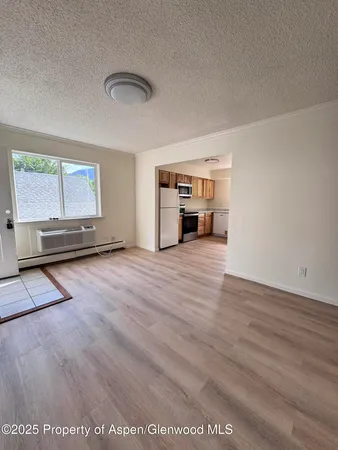 a view of empty room with wooden floor and window