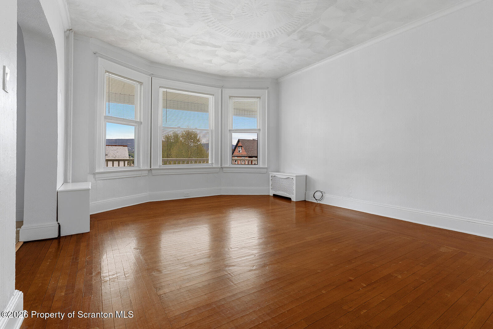 846 Monroe Avenue Scranton, PA 18510 - Photo 12 of 87 a view of an empty room with wooden floor and a window
