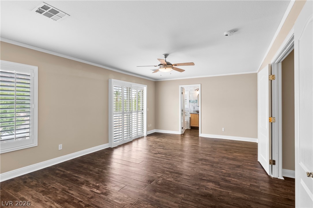 708 Vortex Avenue Henderson, NV 89002 - Photo 27 of 71 Rich hardwood-style flooring and natural light define this inviting primary bedroom.