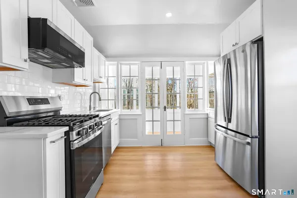 a kitchen with stainless steel appliances a stove sink microwave and cabinets