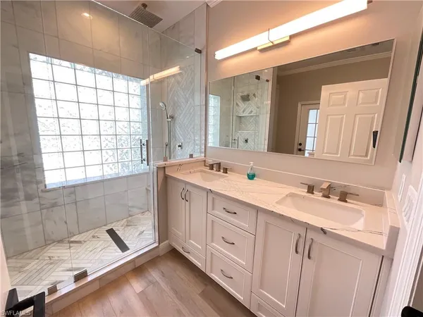 a spacious bathroom with a double vanity sink and a mirror