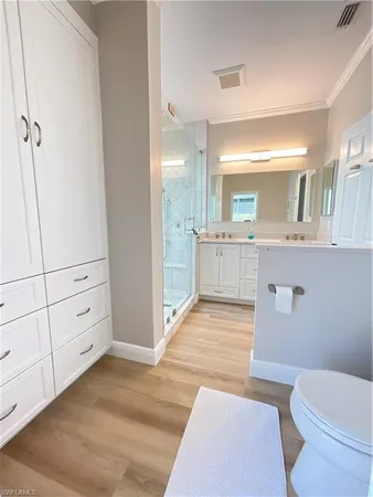 a spacious bathroom with a granite countertop sink mirror vanity and toilet