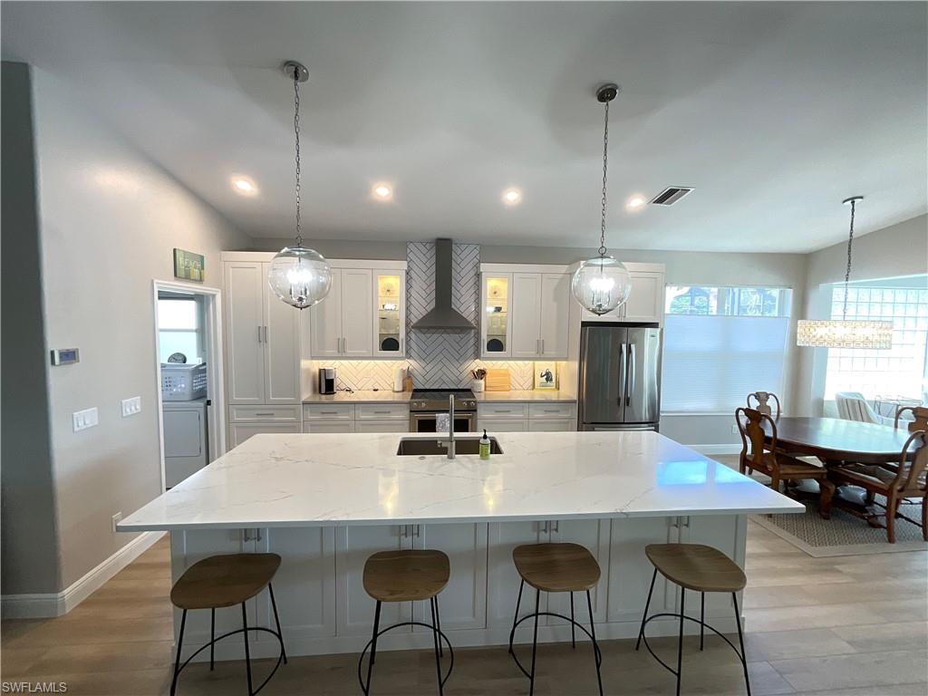 1709 Marsh Run Naples, FL 34109 - Photo 3 of 19 a kitchen with stainless steel appliances kitchen island a table chairs and a refrigerator