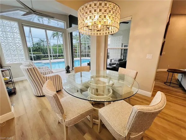 a dining room with furniture a chandelier and wooden floor
