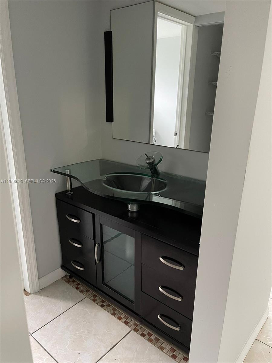 7670 Southwest 82nd Street, Unit H113 Miami, FL 33143 - Photo 14 of 14 a bathroom with a sink and a mirror