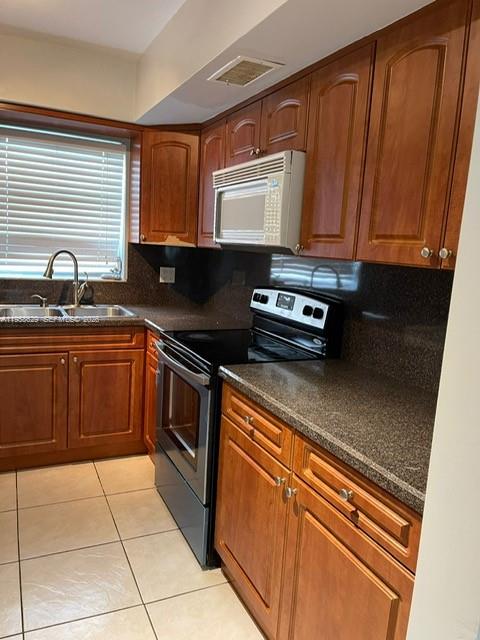 7670 Southwest 82nd Street, Unit H113 Miami, FL 33143 - Photo 5 of 14 a kitchen with stainless steel appliances granite countertop a sink stove and cabinets