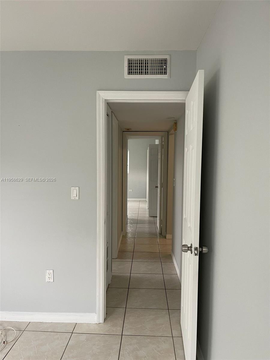 7670 Southwest 82nd Street, Unit H113 Miami, FL 33143 - Photo 10 of 14 a view of a hallway to rooms