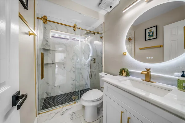 a bathroom with a sink a toilet and shower
