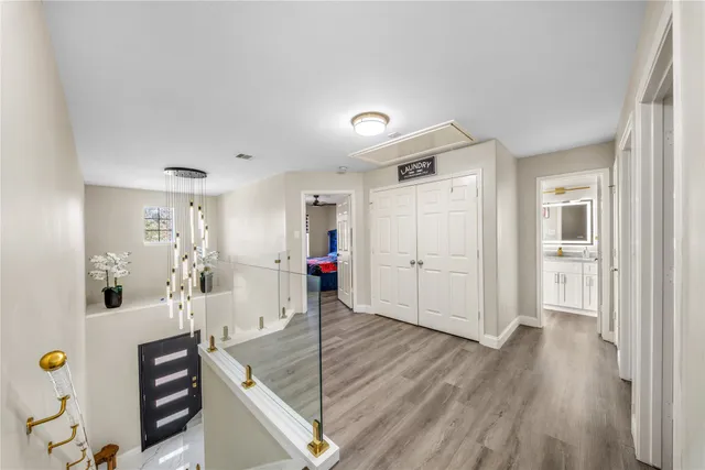 a view of a hallway to a livingroom with furniture wooden floor and window