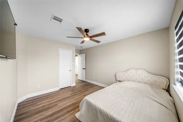 a bedroom with a bed and a ceiling fan