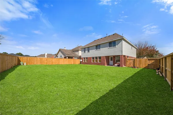 a view of a house with a big yard and large trees