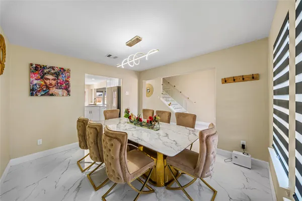 a view of a dining room with furniture and a kitchen