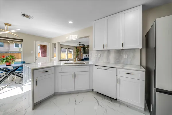 a kitchen with white cabinets and white appliances