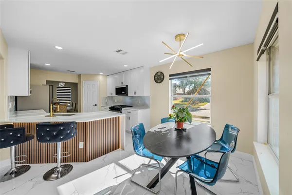 a living room with furniture a dining table and a potted plant