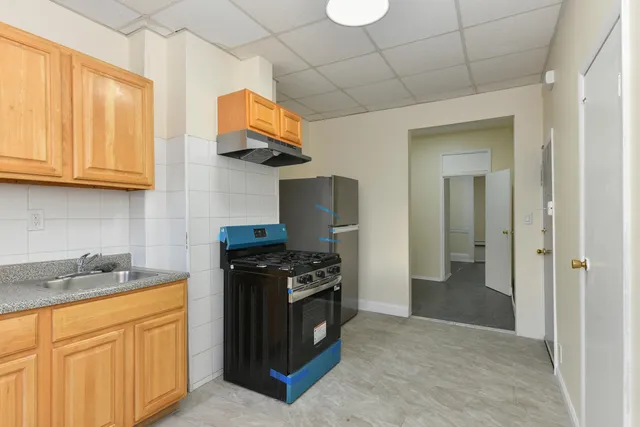 a kitchen with stainless steel appliances granite countertop a stove a sink and a refrigerator