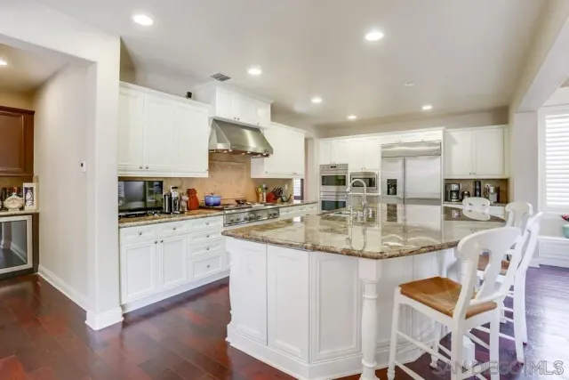 a kitchen with stainless steel appliances granite countertop a stove and white cabinets